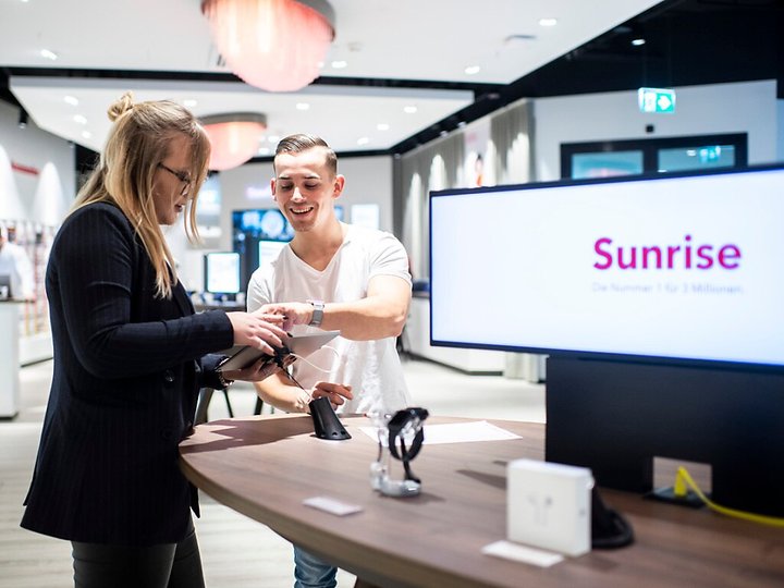 Ein Mitarbeiter von Sunrise zeigt einer Kundin ein Tablet. Er kann sich im laufenden Jahr auf eine Lohnerhöhung freuen. (Symbolbild)