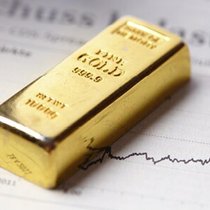 Ein 1-Kilogramm-Goldbarren liegt auf einer Wirtschaftszeitung.