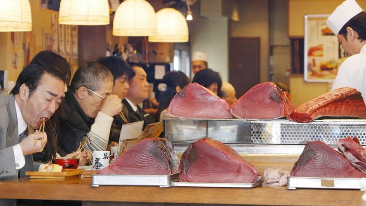 Thunfisch essende Menschen auf dem Tsukiji-Markt in Tokyo. Bild: Keystone