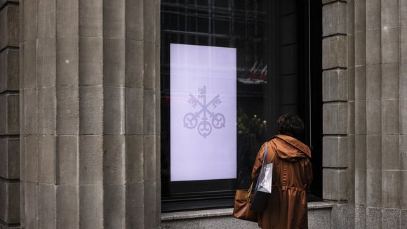 A woman looks at a screen at the entrance of the headquarters of the Swiss bank UBS in Zurich, Switzerland, on Friday, March 24, 2023. (KEYSTONE/Michael Buholzer).
