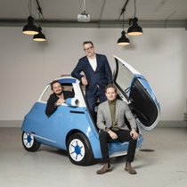 Familienbande: Oliver, Wim und Merlin Ouboter (von links nach rechts) und der Microlino.