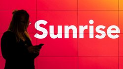 Die Marke bleibt: Mobile-Kundin vor Sunrise-Signet.