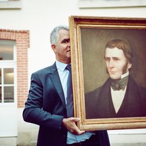 Olivier Krug mit einem Bild des Gründers Joseph Krug.