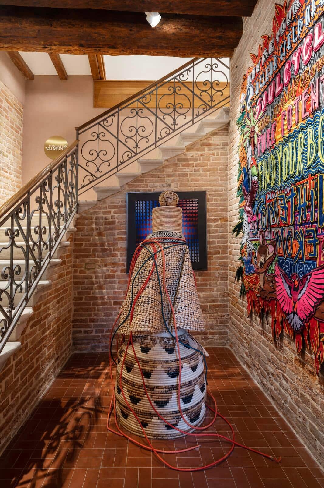 Bereits im Treppenhaus der Fondation Valmont (Bild links) trifft man auf Kunst: Die Skulptur in der Mitte schuf der ugandische Künstler Acaye Kerunen. Die Filz-­Collage rechts ist von Jody Paulsen, an der Stirnseite hängt ein  Werk von Yvaral, Sohn von Victor Vasarely.