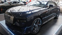 Bei den Black-Badge-Versionen des Rolls-Royce Spectre des Modelljahres 2026 erhalten der Pantheon-Kühlergrill und die „Spirit of Ecstasy“-Kühlerfigur eine dunkel eloxierte Oberfläche