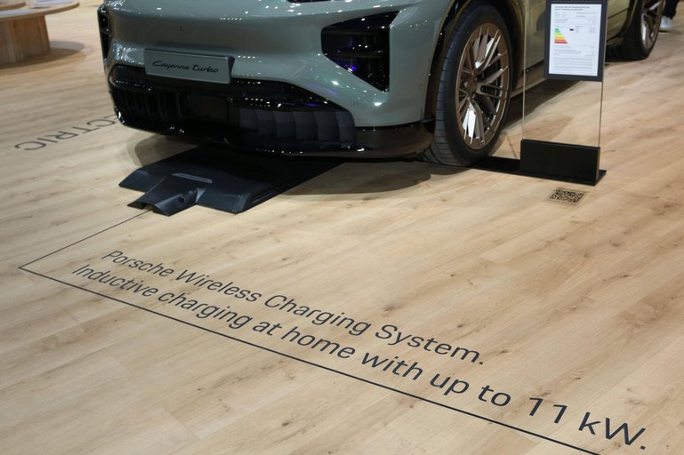 Schriftzug Porsche Wireless charging System auf dem Boden vor Porsche Cayenne turbo electric (Baureihe E4, Elektroauto, 