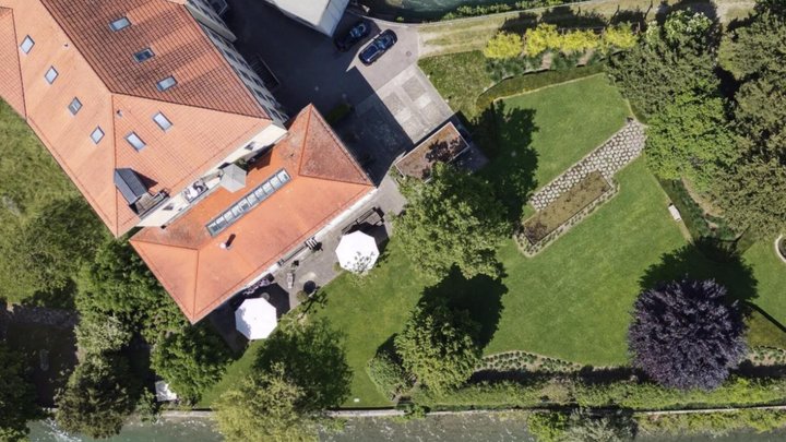 Sie ist an eine Fabrikhalle angebaut und verfügt über eine grosse Terrasse mit Sicht auf den Fluss.