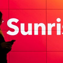 Die Marke bleibt: Mobile-Kundin vor Sunrise-Signet.