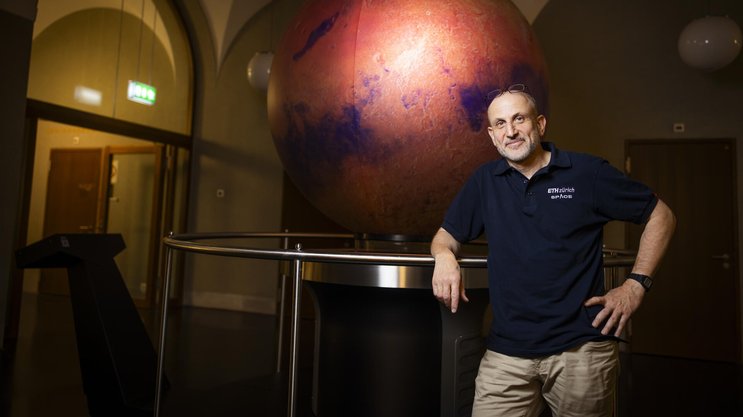 Richard Kornfeld vor dem Omniglobe an der ETH Zürich, der die Oberfläche des Mars zeigt.