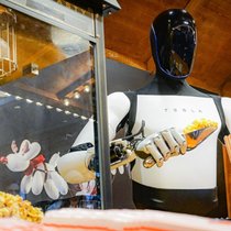 Der humanoide Roboter «Optimus» von Tesla beim Abfüllen von Popcorn in eine Tüte (12.12.2025).