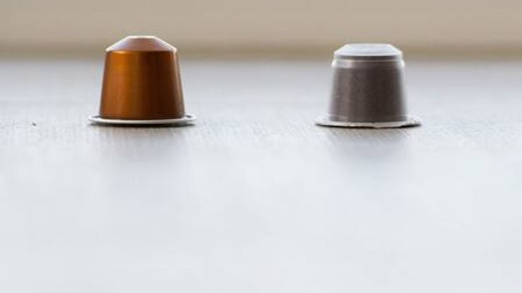Eine Kaffekapsel der Firma Nestlé, links, neben einer Kaffekapsel der Firma Denner, rechts (Bild:Keystone)