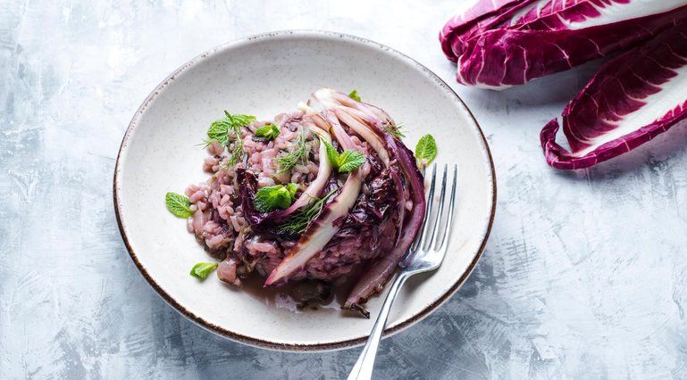 Risotto with radicchio, pancetta and red wine, winter Nord Italy dish. Radicchio chicory (Radicchio rosso di Treviso, Veneto) on the white table. Winter recipes from the north Italy
Risotto aus Radicchio Trevisano
