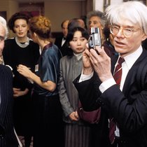 Andy Warhol (rechts) ist kurz davor, Yves Piaget an einem Event zu fotografieren (Washington DC, 1984).