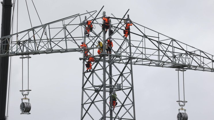 Industriekletterer arbeiten an einem neuen Strommasten.