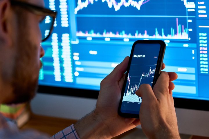 Business man trader investor analyst using mobile phone app analytics for cryptocurrency financial stock market analysis analyze graph trading data index investment growth chart on smartphone screen.
Kryptowährungen