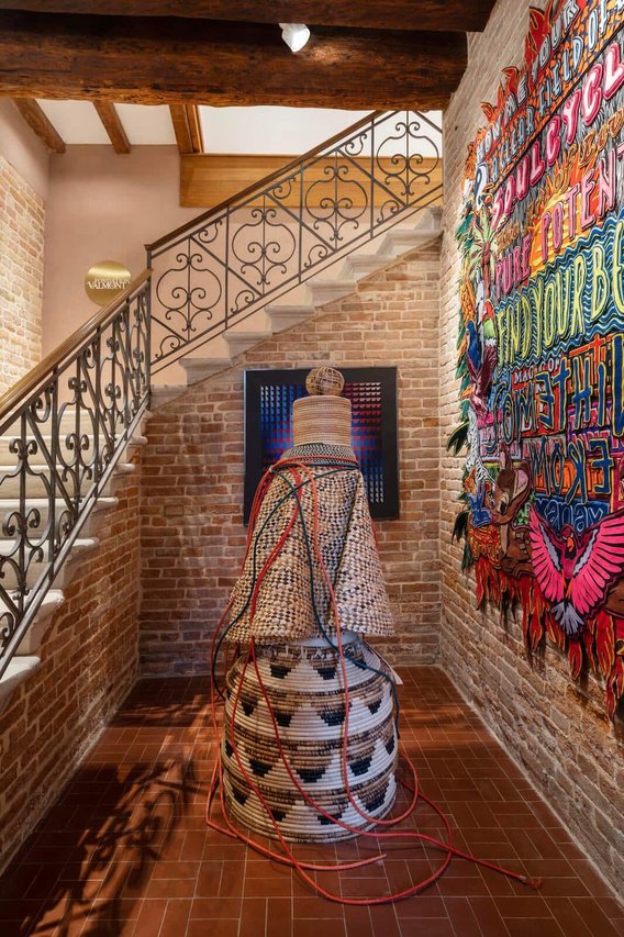 Bereits im Treppenhaus der Fondation Valmont (Bild links) trifft man auf Kunst: Die Skulptur in der Mitte schuf der ugandische Künstler Acaye Kerunen. Die Filz-­Collage rechts ist von Jody Paulsen, an der Stirnseite hängt ein  Werk von Yvaral, Sohn von Victor Vasarely.