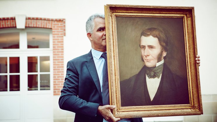 Olivier Krug mit einem Bild des Gründers Joseph Krug.