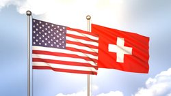 Flaggen der USA und der Schweiz wehen im Wind (2023).