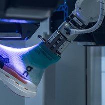 Unter UV-Licht wird die Tinte getrocknet, zu diesem Zeitpunkt ist noch kein Mensch in die Produktion des Schuhs involviert.