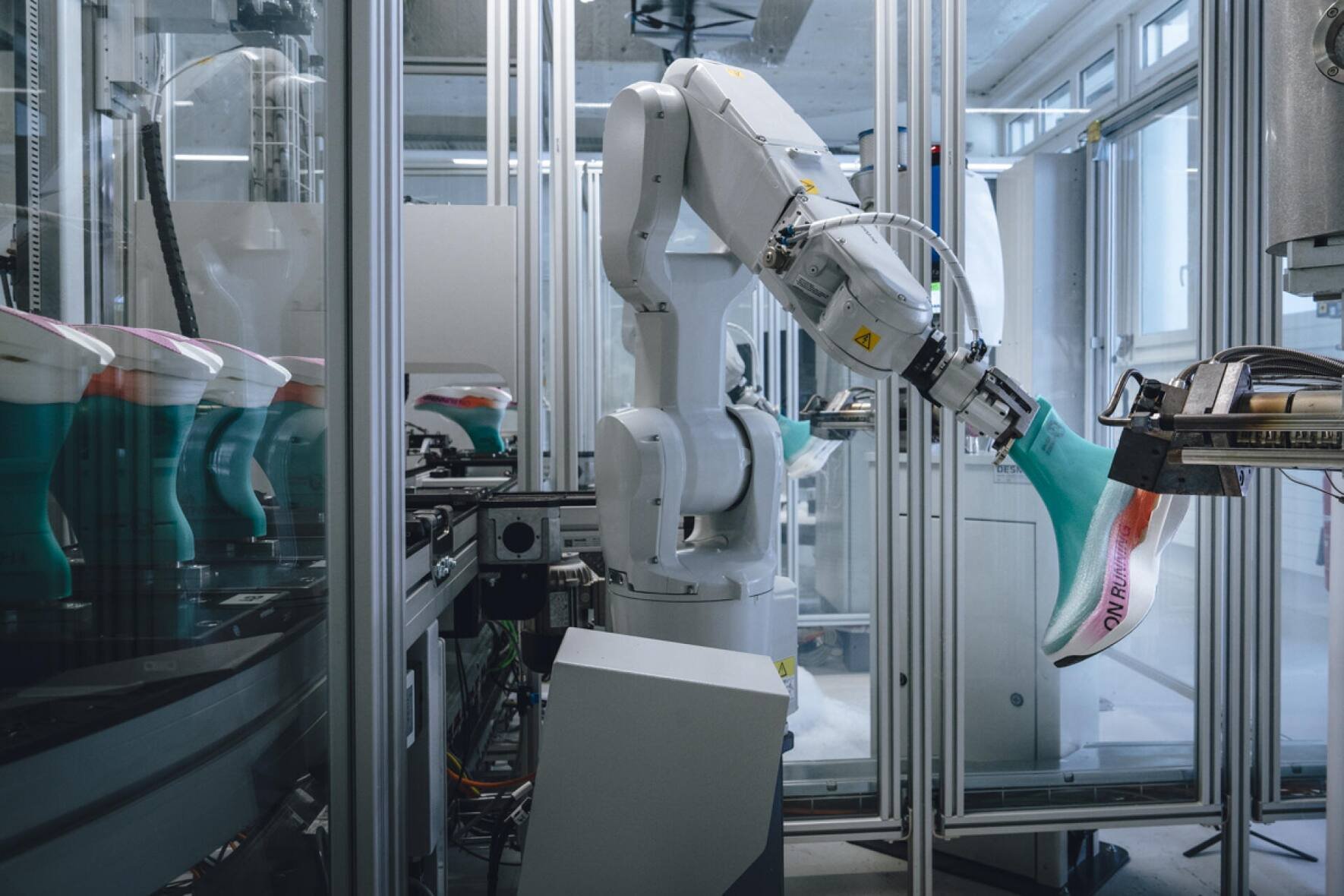 Der Roboter sprüht den Schuh auf den Leisten (in Türkis).