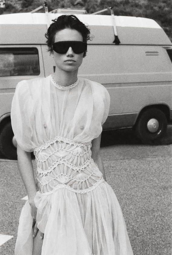 Kurzärmeliges, knöchellanges Kleid aus Seidenorganza mit Makrameedetails. Sonnenbrille aus Azetat, Bottega Veneta.