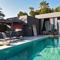 Aus dem grosszügigen Living Room führt der Weg zum Poolbereich mit Blick auf Ibiza-Stadt und aufs offene Meer. Die früher grellweiss gestrichenen Wände hüllte Anja Graf in dunkle Töne.