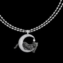 Anhänger mit schwarzen und weissen Diamanten aus der Red-Carpet-Kollektion von Chopard: Ein Panther ruht auf einer Mondsichel.