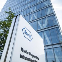 Roche-Logo vor einem Gebäude in Rotkreuz ZG.