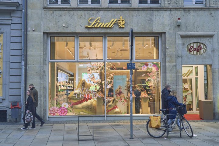 Lindt Schokolade, Lindt-Geschäft mit Osterdekoration, ein Fahrrad davor, zwei Personen gehen vorbei, in Innenstadt von Erfurt, Thüringen, Deutschland Lindt chocolate, Lindt shop with Easter decoration, a bicycle in front of it, two people pass by, in downtown Erfurt, Thuringia, Germany Copyright: imageBROKER/streetxnews iblbee17297708.jpg Bitte beachten Sie die gesetzlichen Bestimmungen des deutschen Urheberrechtes hinsichtlich der Namensnennung des Fotografen im direkten Umfeld der Veröffentlichung