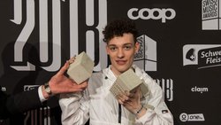 Der Bieler Musiker Nemo posiert im Februar 2018 mit seinen vier Swiss Music Awards vor der Sponsorenwand.