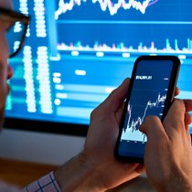 Business man trader investor analyst using mobile phone app analytics for cryptocurrency financial stock market analysis analyze graph trading data index investment growth chart on smartphone screen.
Kryptowährungen