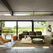 Auf einem handgeknüpften Teppich präsentieren sich ein modulares Sofa und formstarke Couchtische. Das Regal verbindet Wohnlichkeit und Durchsicht. www.zanotta.com
