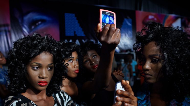 Das Mobilgerät ist eine Bank: Models an einer Modeshow in Lagos, Nigeria.